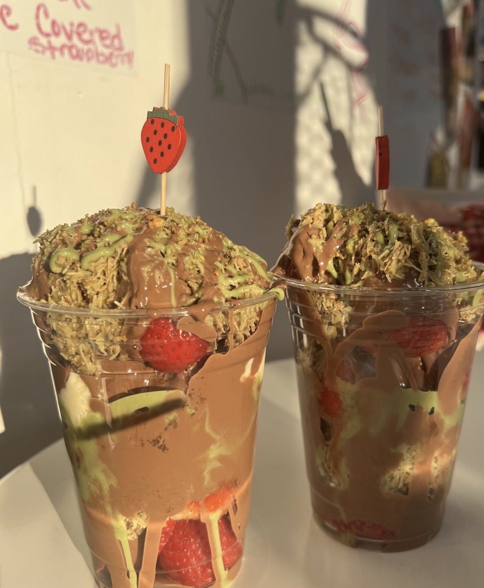Two Dubai chocolate strawberry cups with pistachio kataifi and chocolate drizzle